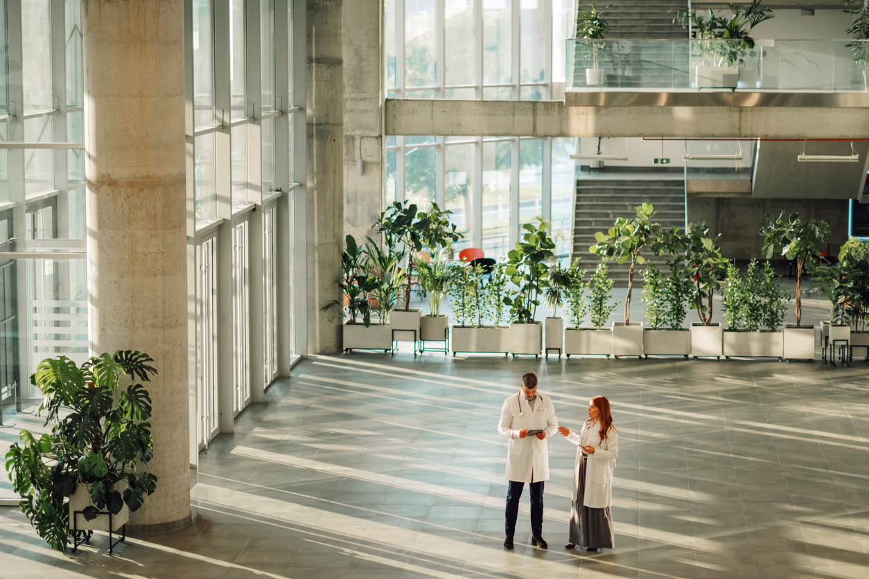 Doctors discussing patient’s medical history in modern hospital lobby